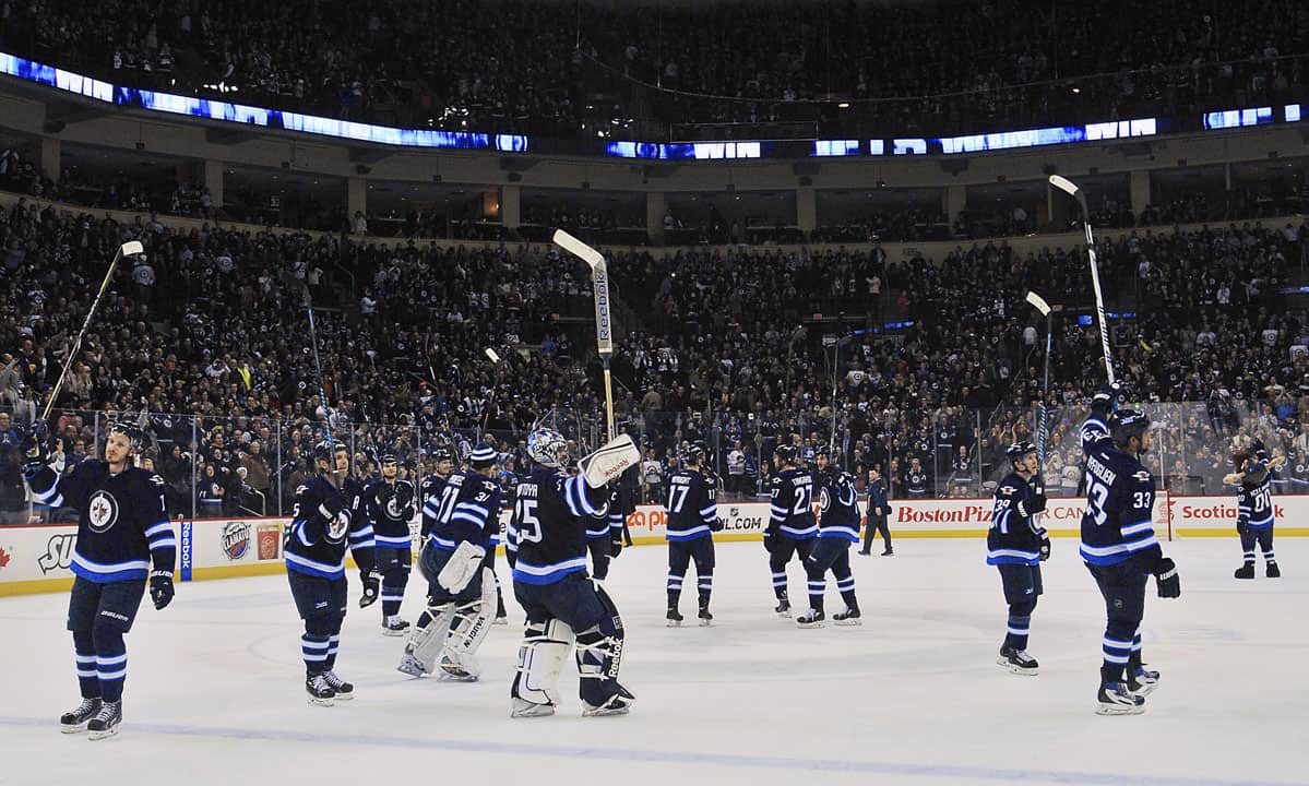 The Winnipeg Jets on the ice, raising their sticks to the crowd